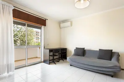 a living room with a couch and a window at Amoreira 3br City Center at Homesbyfc in Faro