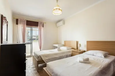 a hotel room with two beds and a window at Amoreira 3br City Center at Homesbyfc in Faro