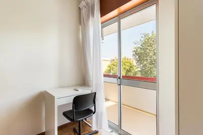 a desk and a chair in a room with a window at Amoreira 3br City Center at Homesbyfc in Faro