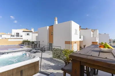 a kitchen with white cabinets and a black counter top at #343 Villa with Pool & Jacuzzi by Home Holidays in Albufeira