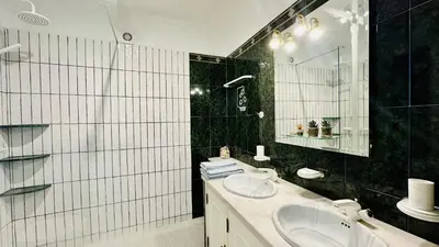 a black and white bathroom with two sinks and a mirror at Villa Verde by Check-in Portugal in Vilamoura