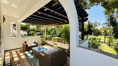 an outdoor patio with wicker chairs and a table at Villa Verde by Check-in Portugal in Vilamoura