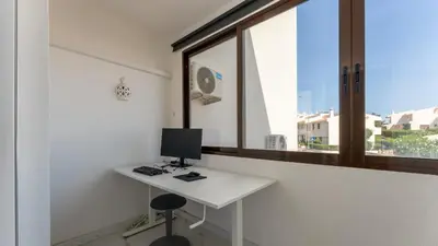 a white desk with a computer on it in front of a window at Bright 1BDR Flat in Albufeira by LovelyStay in Albufeira