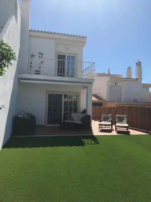 a white house with a yard with green grass at Açoteias Townhouse Villa T2 1 in Roja- Pé