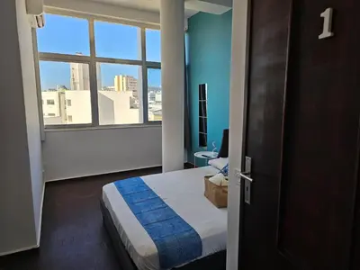 a hotel room with a bed and a window at Blife Eduardya - private rooms at Santantonya 5th floor in Faro