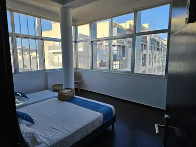 a bedroom with two beds and large windows at Blife Eduardya - private rooms at Santantonya 5th floor in Faro