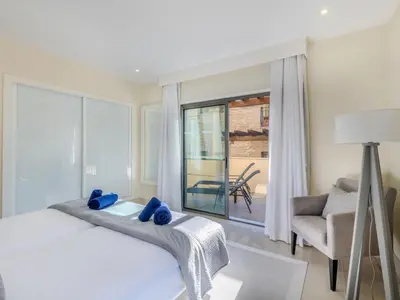 a bedroom with a bed and a chair and a window at Apartment Pine Hills Diadema-16 by Interhome in Vilamoura