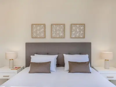 a bedroom with a large white bed with two lamps at Apartment Pine Hills Diadema-16 by Interhome in Vilamoura
