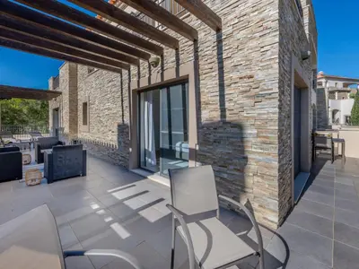 a patio with two chairs and a brick wall at Apartment Pine Hills Diadema-16 by Interhome in Vilamoura