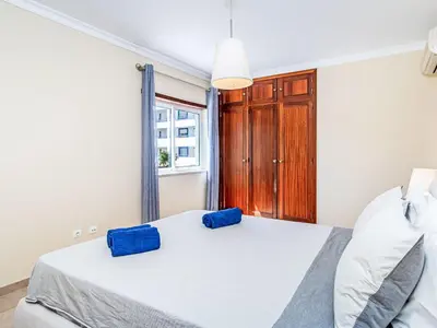a bedroom with a bed with blue pillows on it at Apartment Mediterrâneo by Interhome in Vilamoura