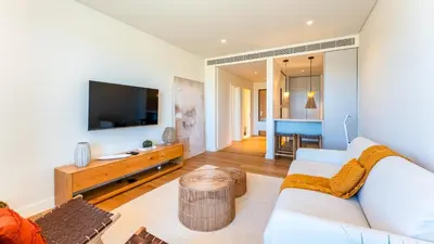 a living room with a white couch and a tv at Luxury Flats with Pool in Quarteira by LovelyStay in Quarteira