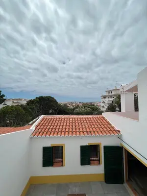 a view of a white house with green shutters at Villa with pool in the Heart of Oura - Albufeira in Albufeira