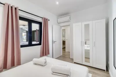 a white room with a bed and a window at Sunshine Apartment in Vilamoura