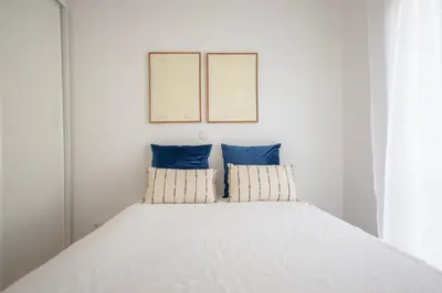 a bedroom with a bed with two blue pillows at Micului Refugiu in Albufeira