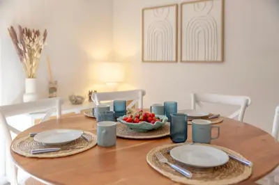 a wooden table with plates and a bowl of fruit on it at Micului Refugiu in Albufeira