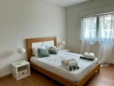 a bedroom with a large white bed with a window at Casa Vila Real in Mem Moniz