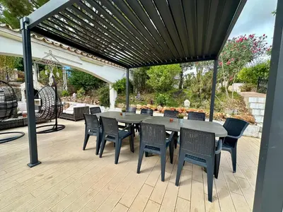 a patio with a table and chairs under a pergola at Casa Vila Real in Mem Moniz
