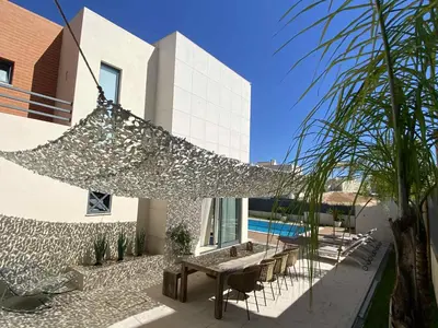 a patio with a hammock on the side of a house at Algarve Boho Beach House in Albufeira