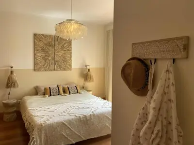 a bedroom with a bed and a chandelier at Algarve Boho Beach House in Albufeira