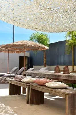 two picnic tables with chairs and an umbrella at Algarve Boho Beach House in Albufeira