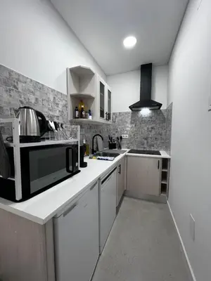 a kitchen with white cabinets and a black microwave at Cantinho da Paz in Faro
