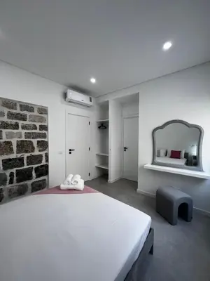 a bedroom with a large white bed and a mirror at Cantinho da Paz in Faro