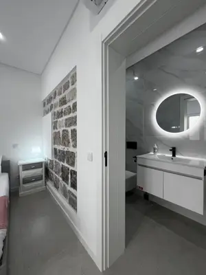 a bathroom with a sink and a brick wall at Cantinho da Paz in Faro