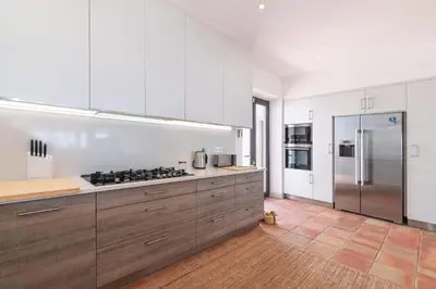 a kitchen with white cabinets and a stainless steel refrigerator at Casa Velha in Loulé