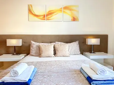 a bedroom with a bed with two lamps and towels at Luxurious T2 with Pool & Breathtaking Ocean Views by BeCherish in Albufeira