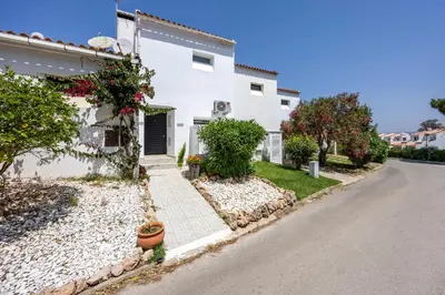 a white house with plants on the side of it at Alfamar Beach Apartment in Albufeira