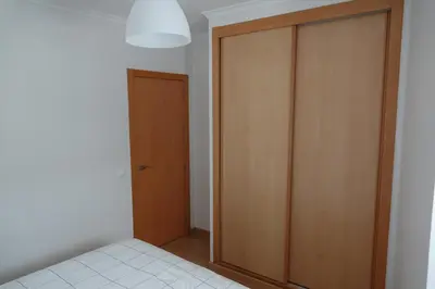 a bedroom with a wooden closet and a door at Blue House - City's Heart in Faro