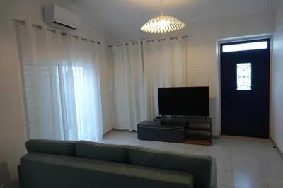 a living room with a couch and a flat screen tv at Blue House - City's Heart in Faro