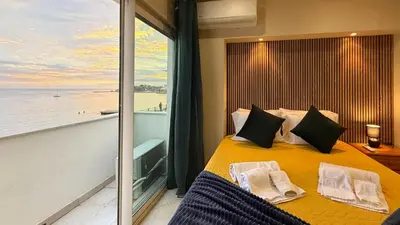 a bedroom with a yellow bed with a large window at Apartamento T1 Pau da Bandeira in Caliços
