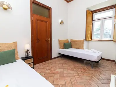 a room with two beds and a window and a bench at Casa Algarvia Senhorial by Stay ici Algarve Holiday Rental in Albufeira