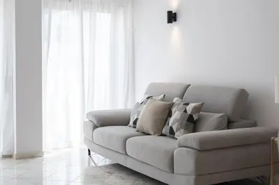 a couch in a living room with white curtains at Mango 2 - Faro City Center by HD in Faro