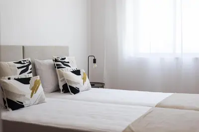 a bedroom with a bed with white sheets and pillows at Mango 2 - Faro City Center by HD in Faro