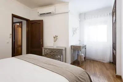 a white bedroom with a bed and a window at Mango 2 - Faro City Center by HD in Faro