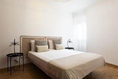 a white bedroom with a large bed with pillows at Mango 2 - Faro City Center by HD in Faro