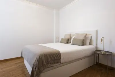 a white bedroom with a large white bed with pillows at Mango 2 - Faro City Center by HD in Faro