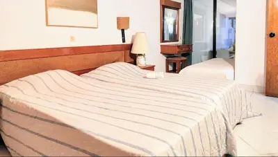 a bedroom with a bed with a striped blanket at Ocean view Cerro Branco with pool in Albufeira