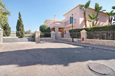 a large house with a fence and a driveway at Sunshine Villa em Vilamoura in Vilamoura