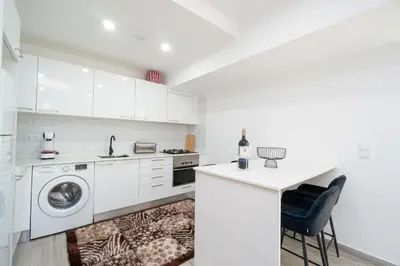 a white kitchen with a washing machine and a washer at Casa Biabella in Albufeira