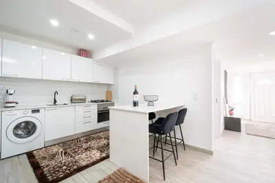 a white kitchen with a sink and a dishwasher at Casa Biabella in Albufeira