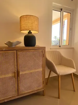 a lamp sitting on top of a dresser next to a chair at Vale de Lobo - stylish beach and golf retreat in Almancil