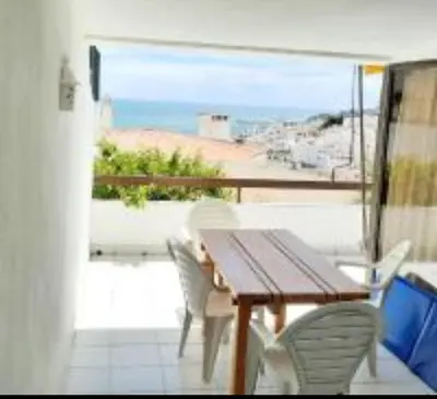 a table and chairs on a balcony with a view of the beach at Albufeira Pescadores Sea view in Albufeira