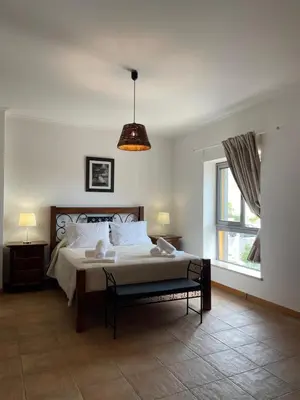 a bedroom with a large bed and a window at Casas da Corujeira Algarve in Albufeira