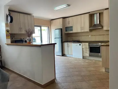 a kitchen with wooden cabinets and a counter top at Casas da Corujeira Algarve in Albufeira