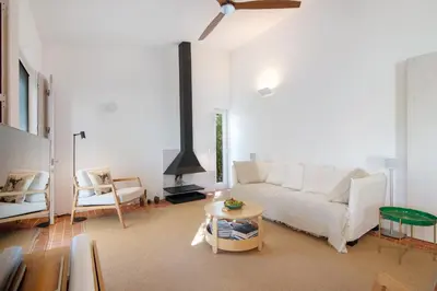 a living room with a white couch and a fireplace at Espuma do Tempo in Quarteira