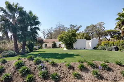 a yard with palm trees and a house at Espuma do Tempo in Quarteira