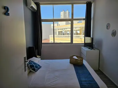 a bedroom with a bed and a large window at Blife Spanya - private rooms at Santantonya 3rd floor in Faro